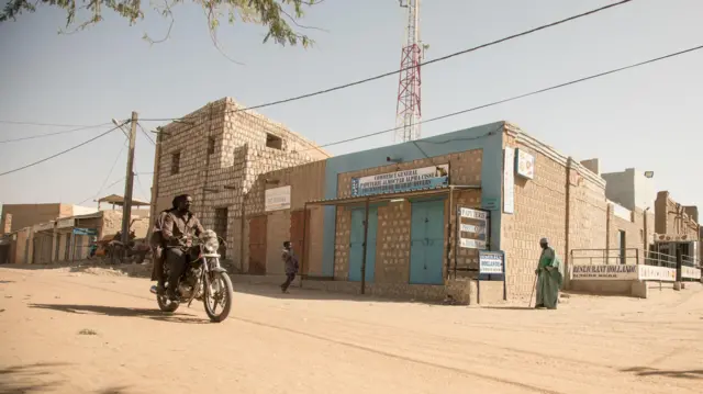 Ville de Tombouctou, au Mali : une rue poussiéreuse bordée de bâtiments en parpaings.