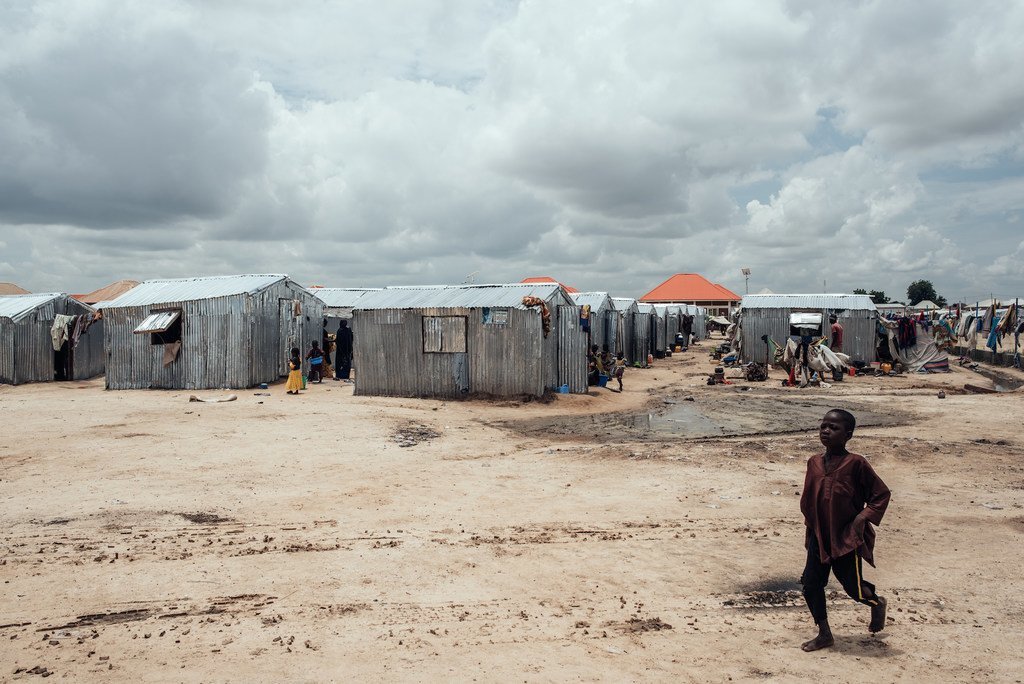 Un enfant marche devant des abris dans un camp de déplacés à Maiduguri, dans l'État de Borno, au Nigeria.