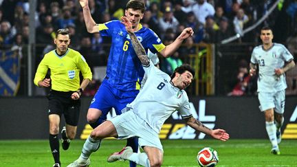 Le joueur de la Bosnie-Herzégovine, Benjamin Tahirovic, se bat pour le ballon avec l'Italien Sandro Tonali, lors du match décisif des qualifications européennes pour la Coupe du monde de la FIFA 2026, au stade Bilino-Polje de Zenica, le 31 mars 2026. (ELVIS BARUKCIC / AFP)
