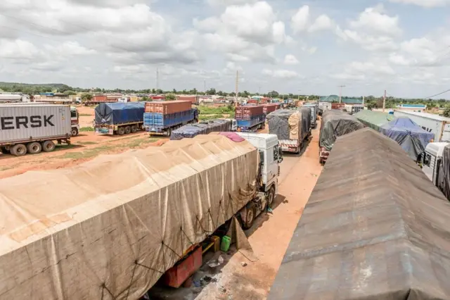 Une longue file de camions fait la queue à la frontière fermée entre le Bénin et le Niger, dans la ville de Malanville, illustrant les conséquences économiques de la crise.