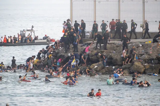 Des personnes traversent la frontière vers Ceuta.
